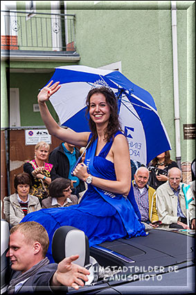 Frau lächelt wieder mit geöffnetem Regenschirm